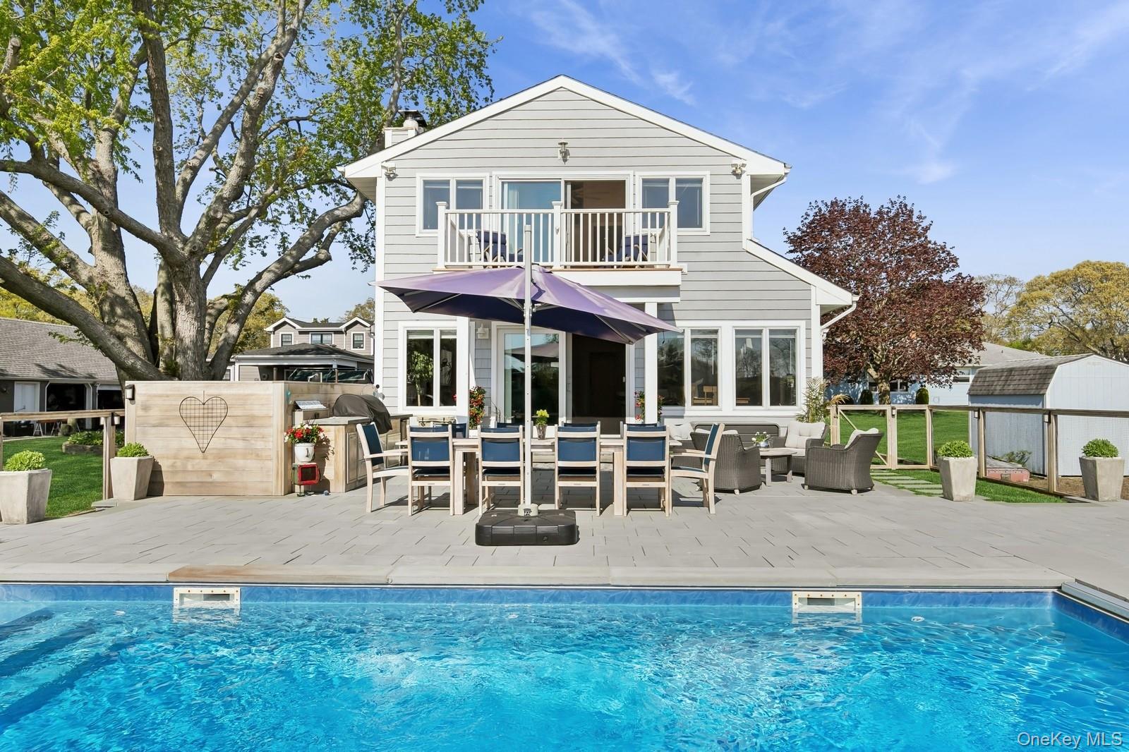 81 Beach Road Aquebogue, NY 11901 - Photo 5 of 34 a front view of a house with garden and sitting area