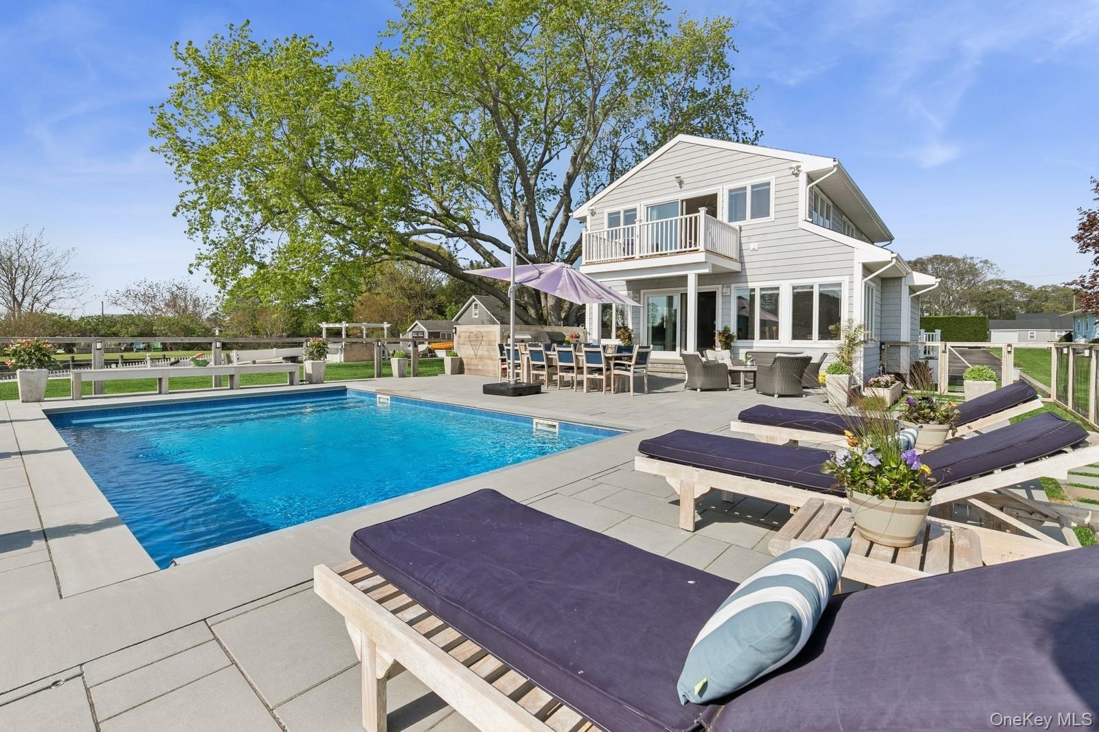 81 Beach Road Aquebogue, NY 11901 - Photo 7 of 34 a front view of a house with swimming pool garden and outdoor seating