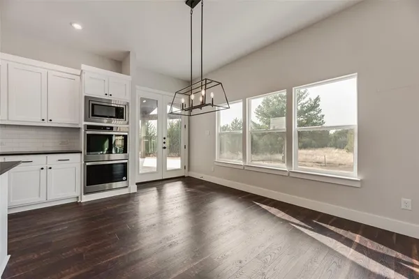 a kitchen with granite countertop a stove and a wooden floors