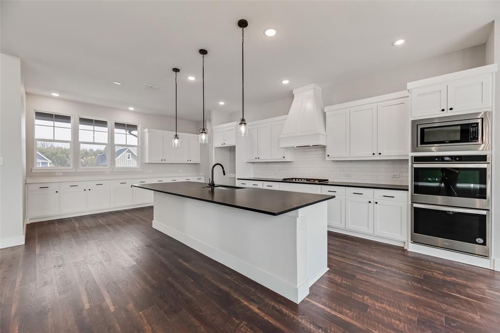 2335 Providence Way Nevada, TX 75173 - Photo 5 of 18 a kitchen with stainless steel appliances granite countertop a sink a stove and a wooden floors