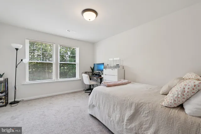 a bedroom with a bed and a large window