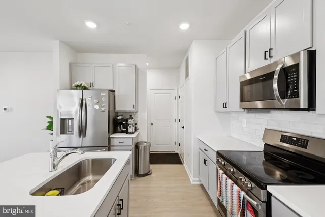 a kitchen that has a sink and a stove top oven