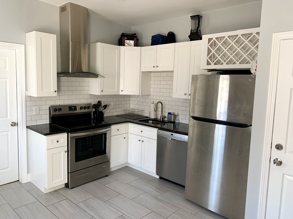 153 Chestnut Street, Unit 1 Waltham, MA 02453 - Photo 1 of 10 a kitchen with stainless steel appliances a refrigerator a sink and white cabinets