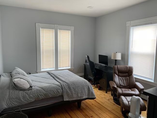 153 Chestnut Street, Unit 1 Waltham, MA 02453 - Photo 2 of 10 a bedroom with a bed and chair