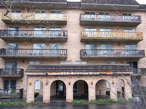 a front view of building with granite countertop lots of windows and plants