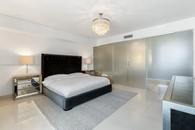 a bedroom with a bed and a chandelier