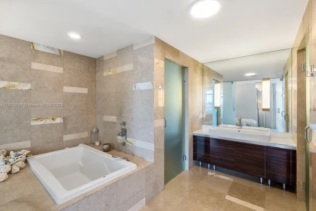 a bathroom with a tub sink and mirror