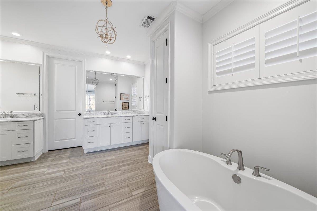 9074 Baynard Loop North Germantown, TN 38139 - Photo 17 of 36 a bathroom with a double vanity sink a mirror a bathtub and with shower