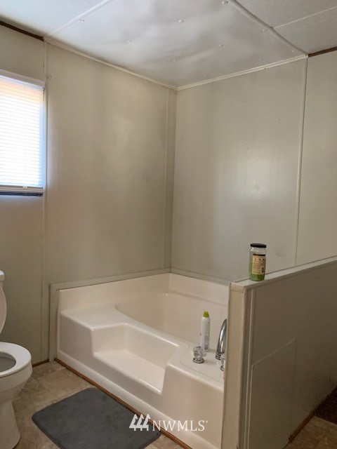 9922 180th Way Southwest Rochester, WA 98579 - Photo 12 of 15 a bathroom with a bathtub and a toilet