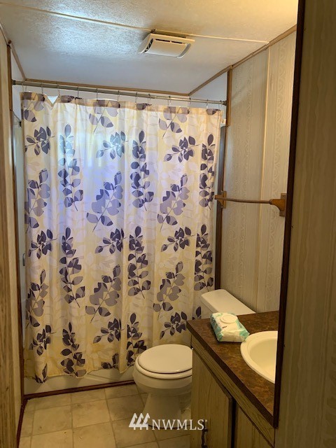 9922 180th Way Southwest Rochester, WA 98579 - Photo 14 of 15 a bathroom with a toilet and shower curtain