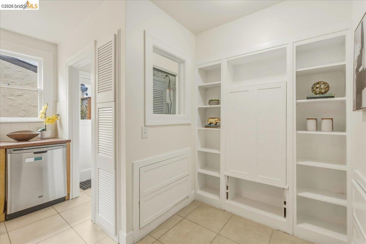 2403 Cedar Street Berkeley, CA 94708 - Photo 10 of 33 Built-in shelving and cabinetry offer extensive storage, complemented by a stainless steel dishwasher and a wood-finish countertop