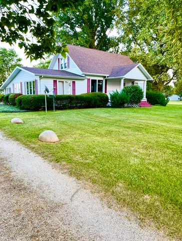 a front view of a house with a yard and trees