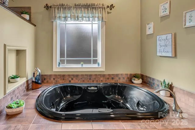 a bed sitting in a bedroom next to a lamp