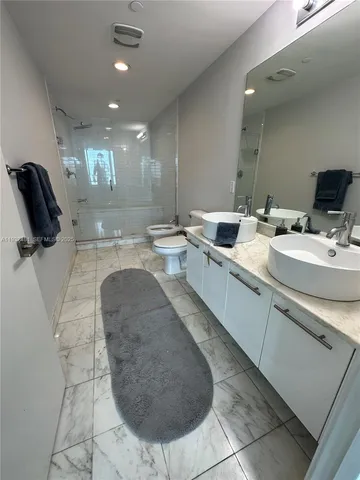 a bathroom with a sink a toilet and mirror