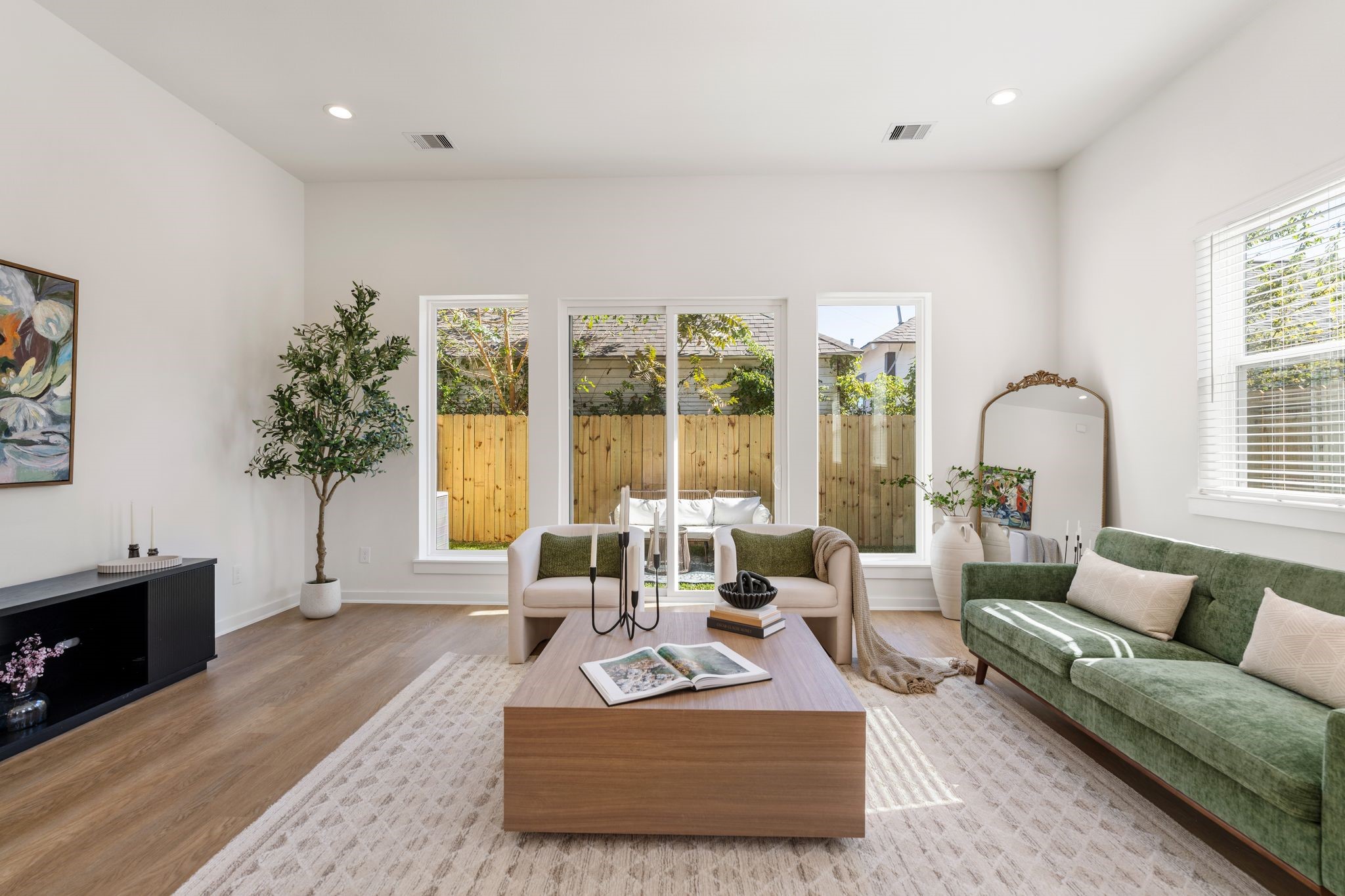 1215 Sampson Street Houston, TX 77003 - Photo 11 of 35 Spacious living room featuring high ceilings and large glass doors that fill the space with natural light and provide a seamless connection to the backyard.