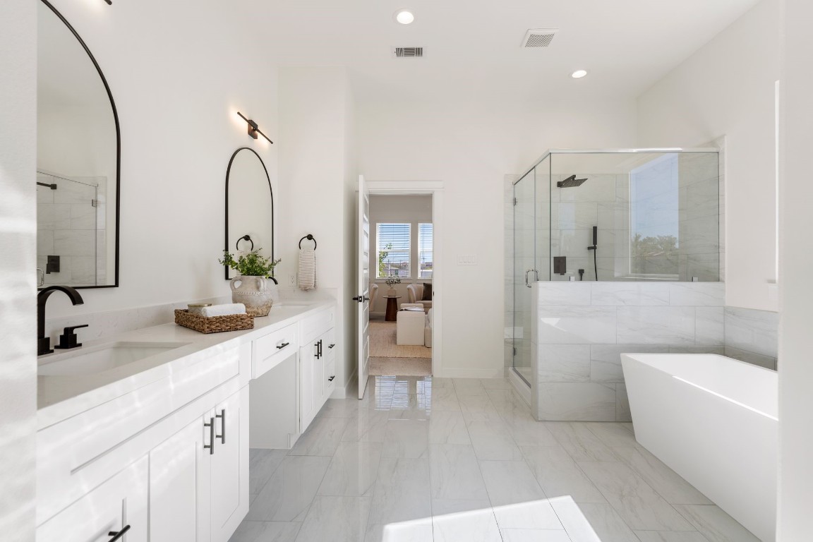 1215 Sampson Street Houston, TX 77003 - Photo 19 of 35 Primary bedroom's ensuite bathroom features dual sinks, soaking tub, and separate walk-in shower.