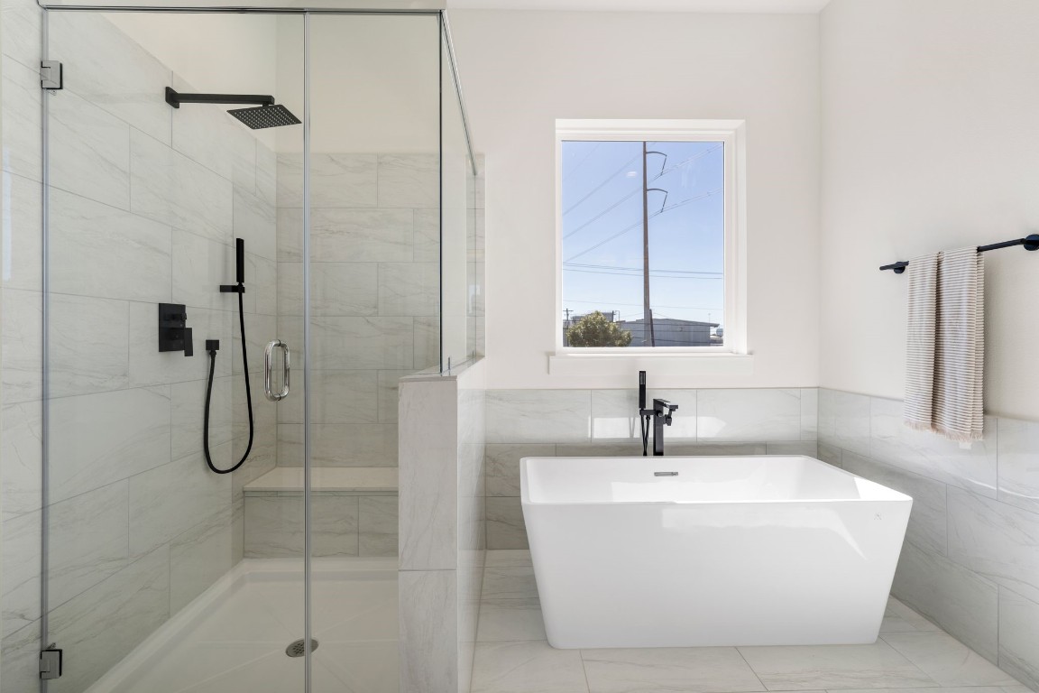 1215 Sampson Street Houston, TX 77003 - Photo 20 of 35 A closer look at the grand soaking bathtub with standing tub filler and sprayer, semi-frameless walk-in shower with a rain shower head.