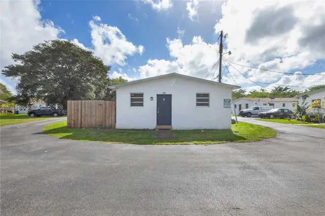 a view of a house with a yard and fence