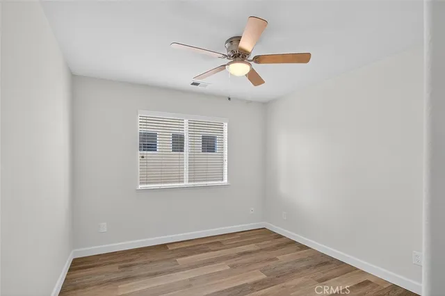 a view of room with hardwood floor and ceiling fan