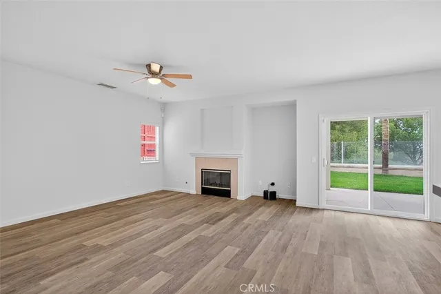an empty room with windows and fireplace