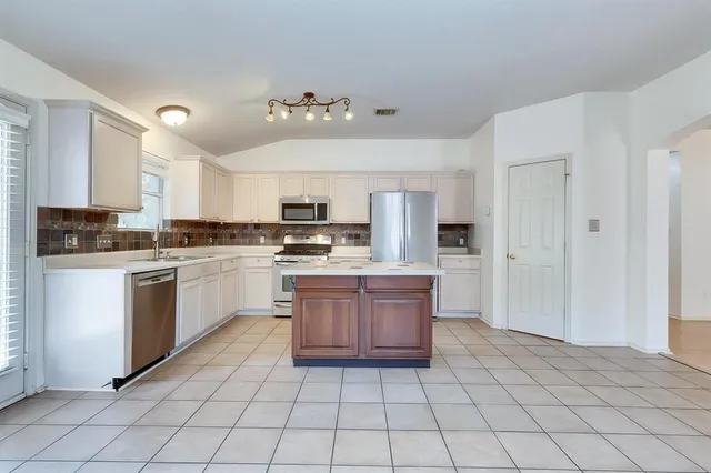 a kitchen with stainless steel appliances granite countertop a refrigerator sink and cabinets