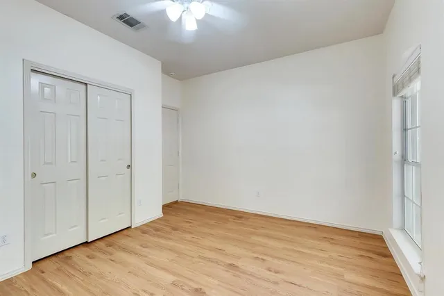 a view of empty room with wooden floor