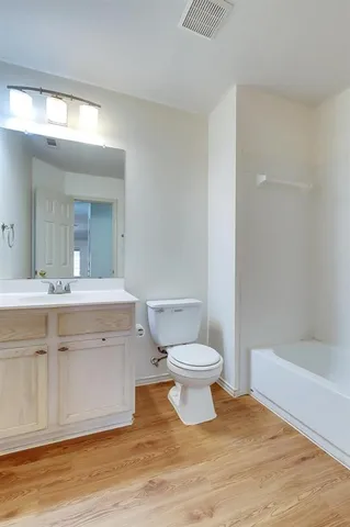 a bathroom with a sink a toilet a mirror and shower