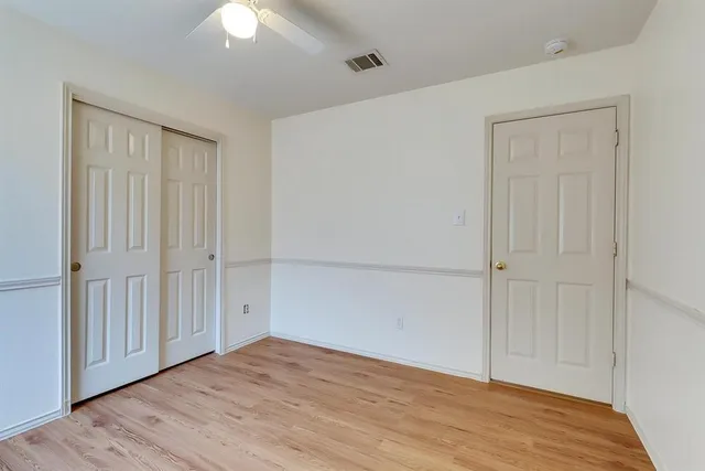 a view of an empty room with wooden floor