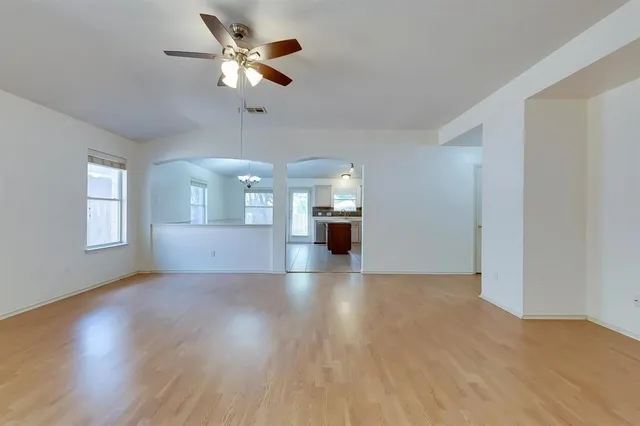 a view of a livingroom with a ceiling fan window and wooden floor