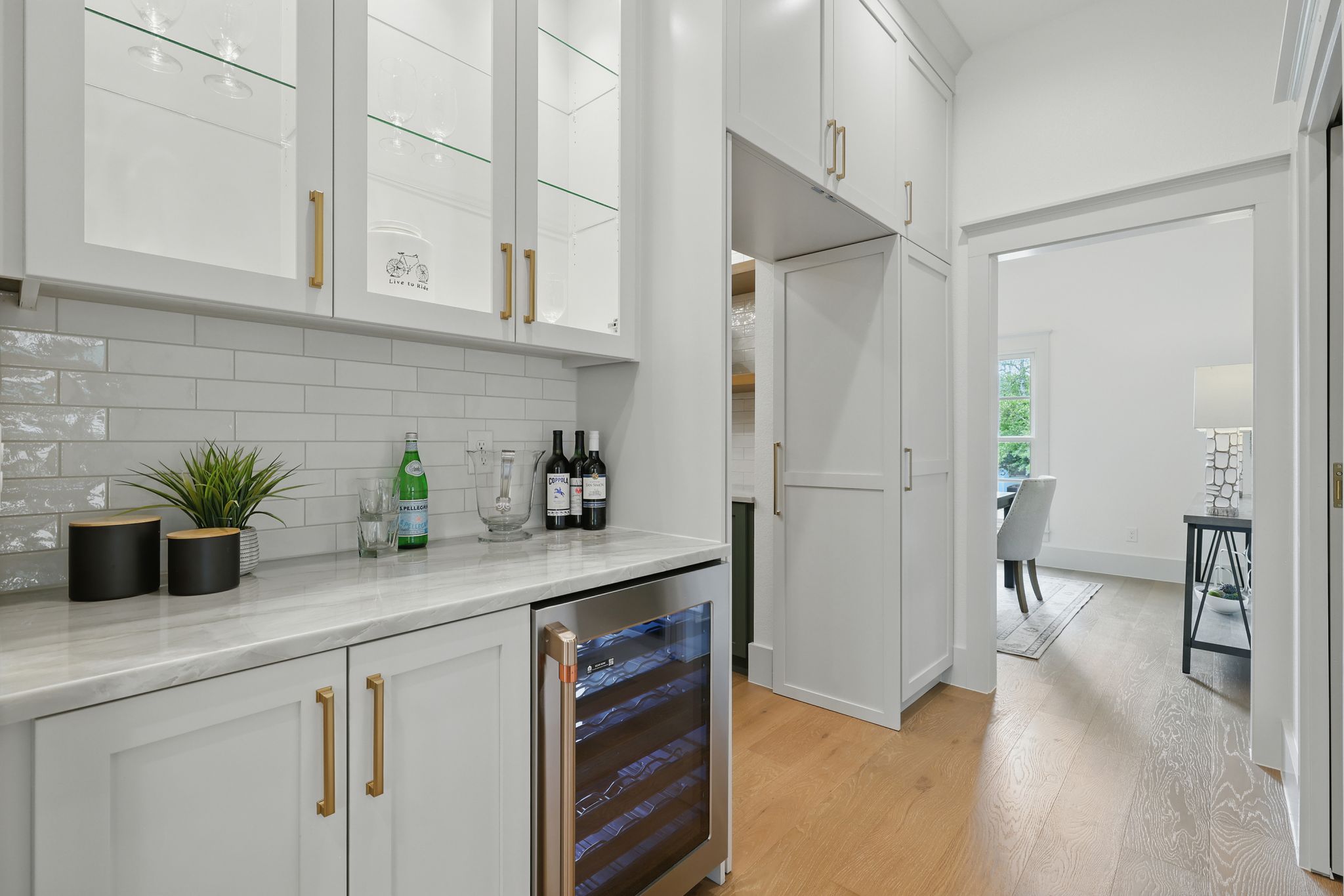 6905 Rudi Cove Austin, TX 78759 - Photo 14 of 36 Indoor dry bar with beverage cooler, light wood-type flooring, and tasteful backsplash