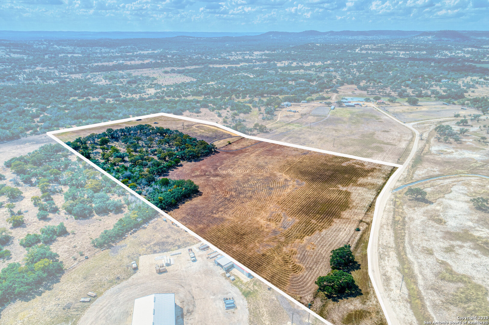 261 Watering Hole Trail Bandera, TX 78003 - Photo 23 of 24 a view of a dry yard with wooden floor