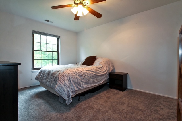 29 Stanton Court, Unit C2 Schaumburg, IL 60193 - Photo 6 of 9 a spacious bedroom with a bed and a chandelier