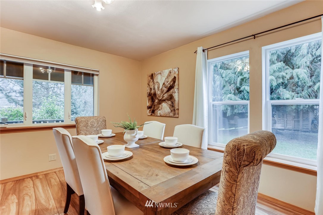 3427 Southeast 7th Street Renton, WA 98058 - Photo 13 of 32 a view of a dining room with furniture large windows and wooden floor