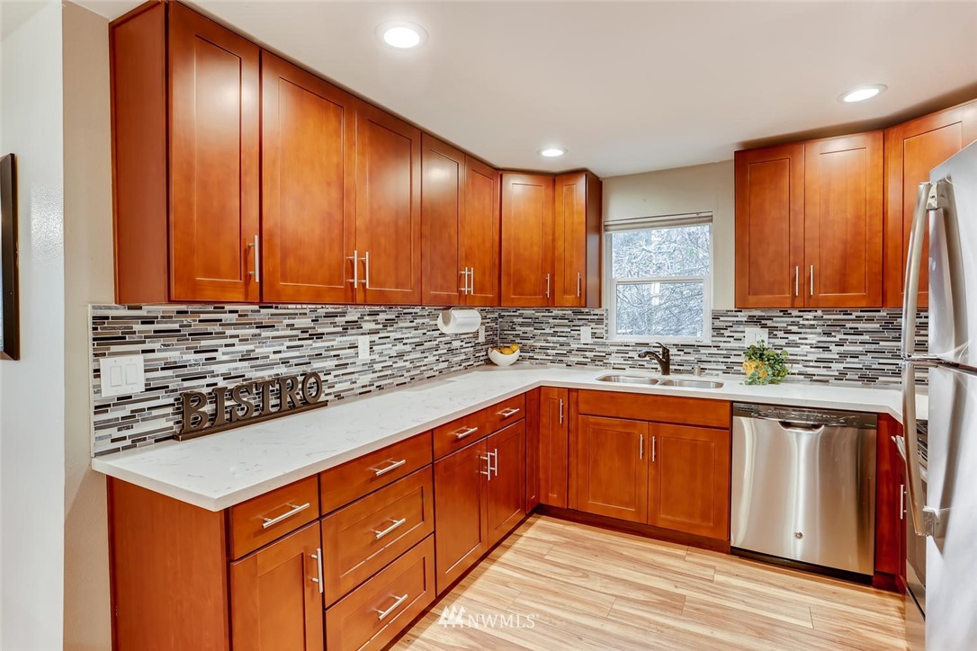 3427 Southeast 7th Street Renton, WA 98058 - Photo 17 of 32 a kitchen with stainless steel appliances granite countertop wooden cabinets a sink and dishwasher