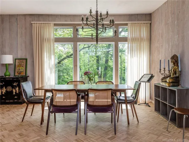 a dining room with furniture a chandelier and wooden floor