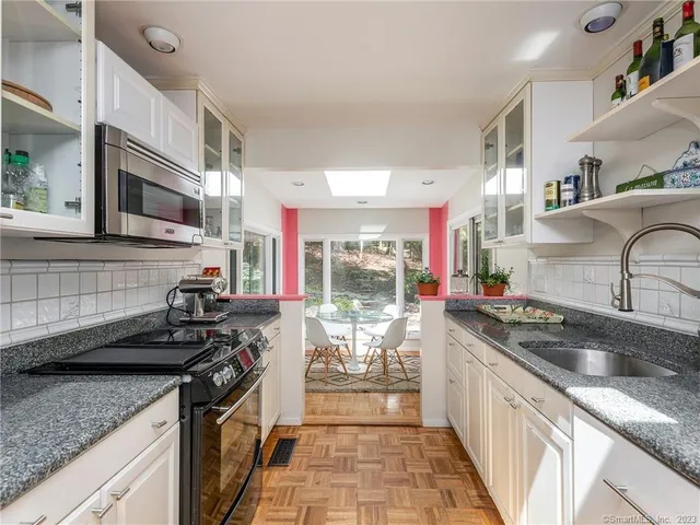 a kitchen with stainless steel appliances granite countertop a sink stove and cabinets