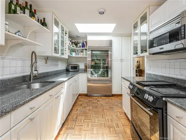 a kitchen with stainless steel appliances granite countertop a sink stove and cabinets