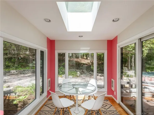 a dining room with wooden floor and a floor to ceiling window