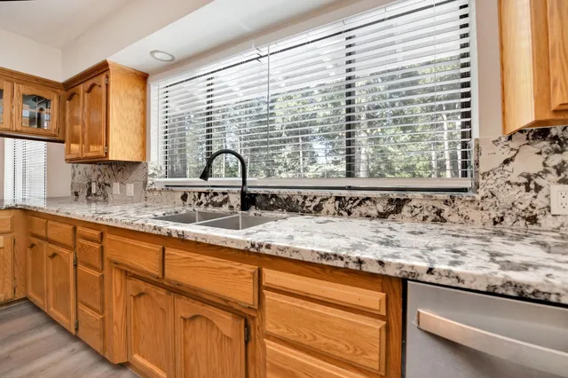 a bathroom with a granite countertop tub a sink and mirror