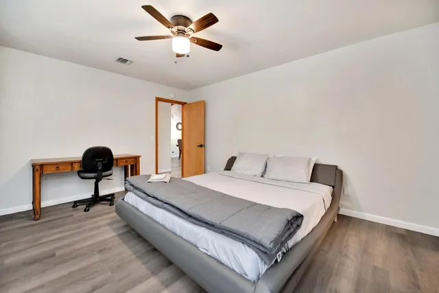 a kitchen with granite countertop a stove a sink cabinets and wooden floor