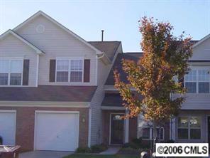 a front view of a house with a tree