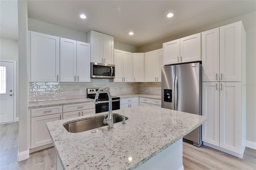 9 Seton Place, Unit A Palm Coast, FL 32164 - Photo 11 of 31 a kitchen with stainless steel appliances granite countertop a sink a stove and a refrigerator