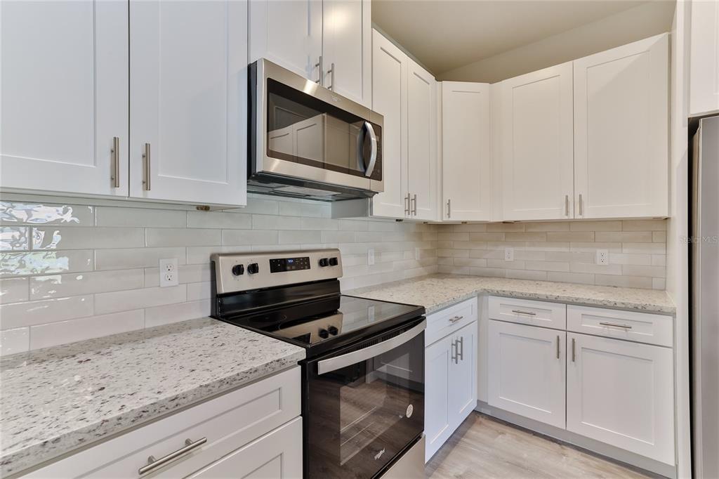 9 Seton Place, Unit A Palm Coast, FL 32164 - Photo 12 of 31 a kitchen with white cabinets appliances and a sink