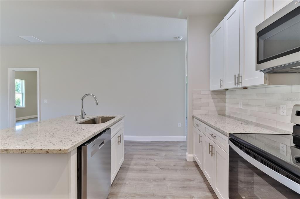 9 Seton Place, Unit A Palm Coast, FL 32164 - Photo 14 of 31 a kitchen with granite countertop a sink and a stove