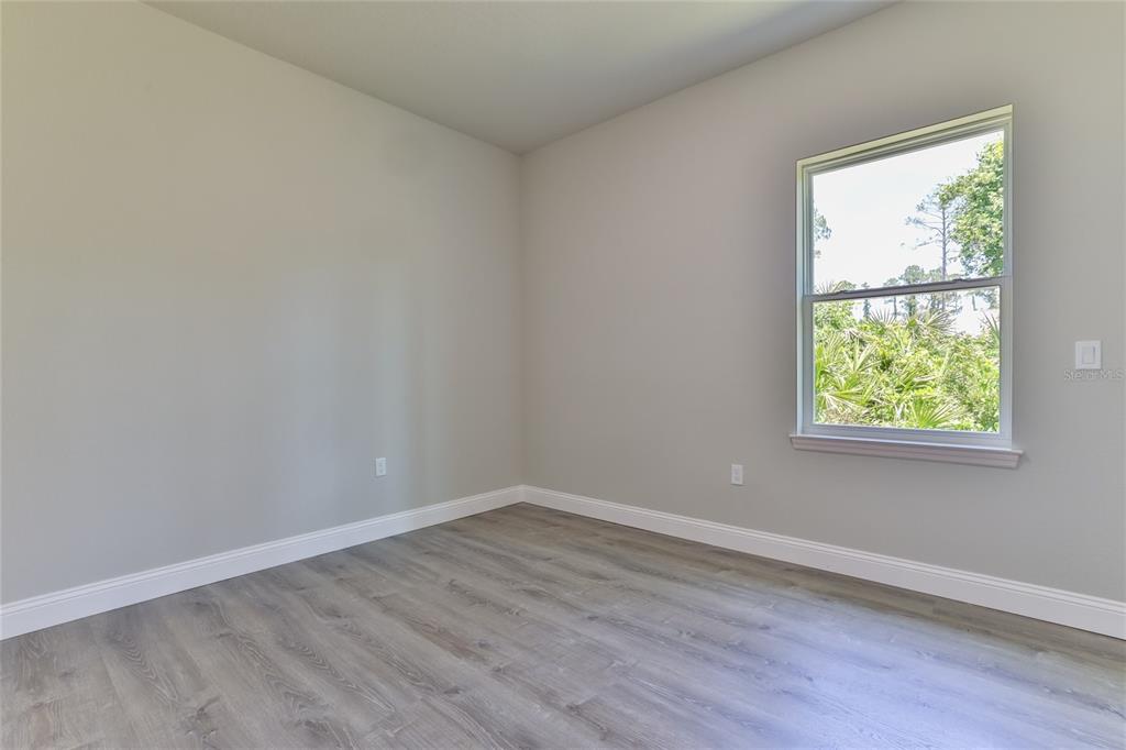 9 Seton Place, Unit A Palm Coast, FL 32164 - Photo 21 of 31 an empty room with wooden floor and windows