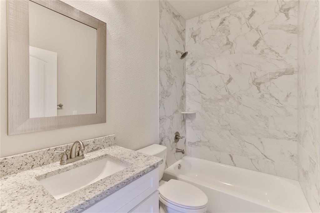 9 Seton Place, Unit A Palm Coast, FL 32164 - Photo 23 of 31 a bathroom with a granite countertop sink toilet and shower