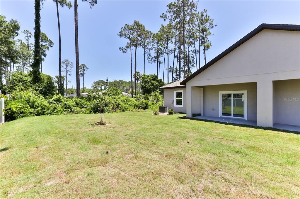 9 Seton Place, Unit A Palm Coast, FL 32164 - Photo 27 of 31 a front view of a house with a yard and trees