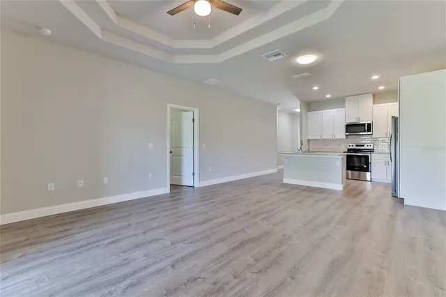 a view of a kitchen with wooden floor and a window