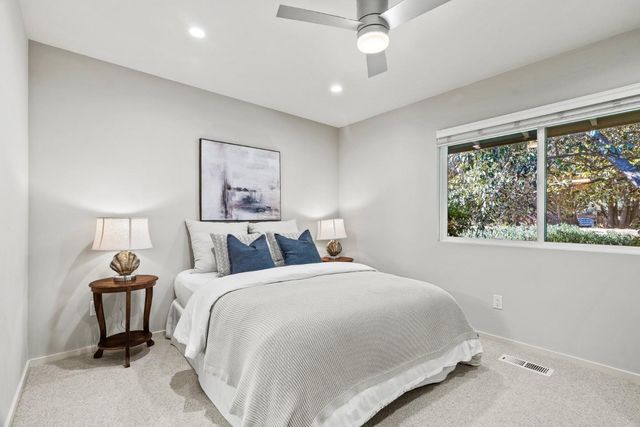 a bedroom with a bed and a painting on the wall