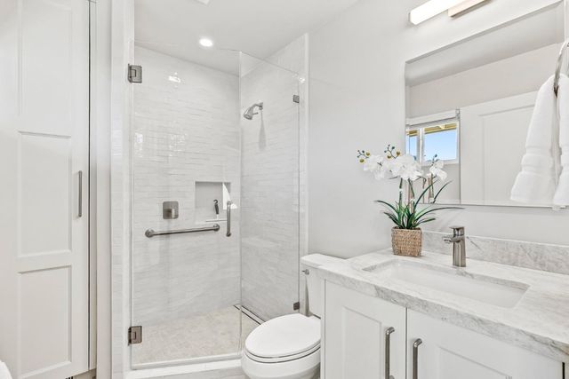 a bathroom with a granite countertop sink a toilet and shower